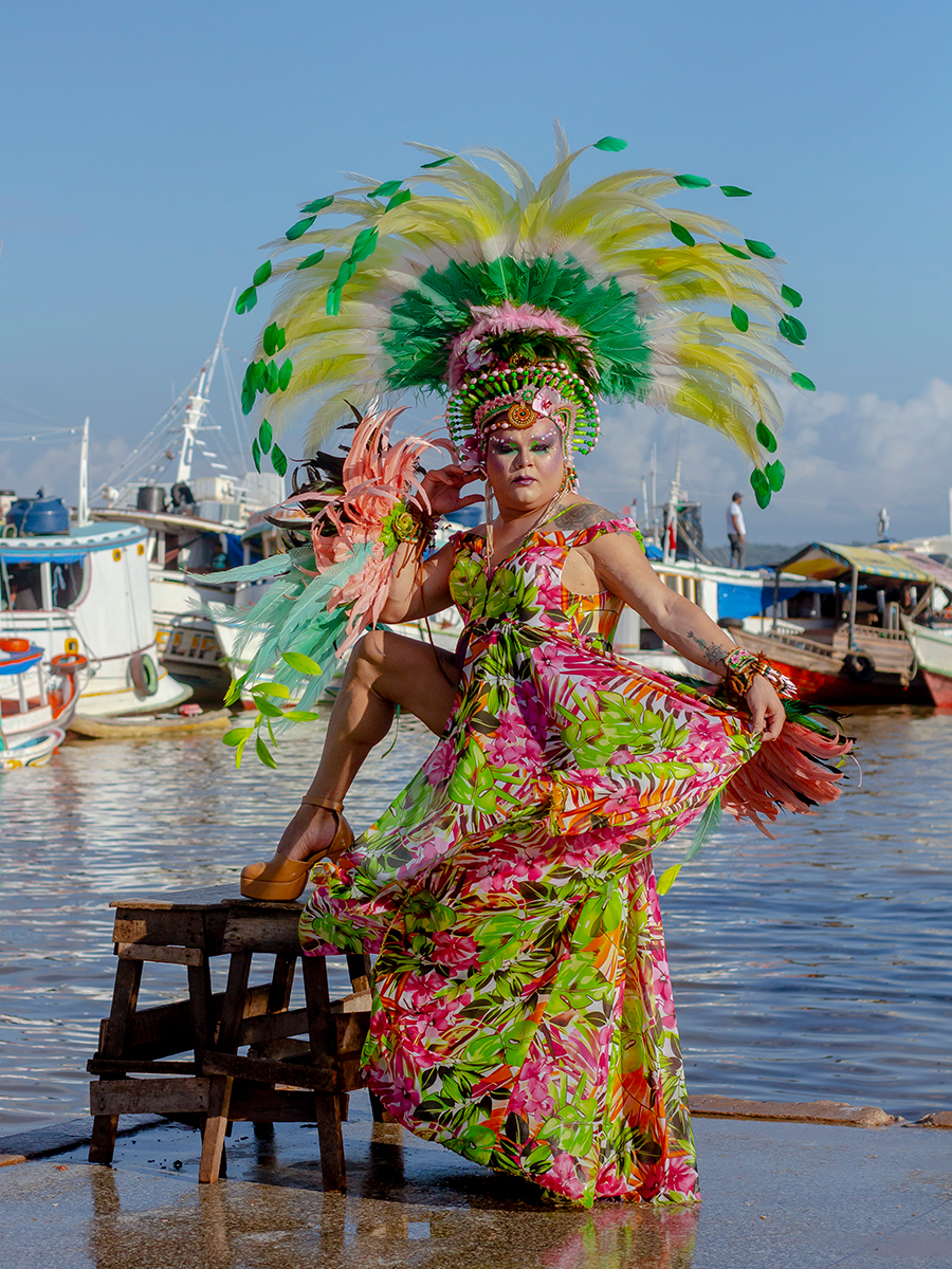 Drag de verde e rosa no mercado Ver-o-Peso com barcos