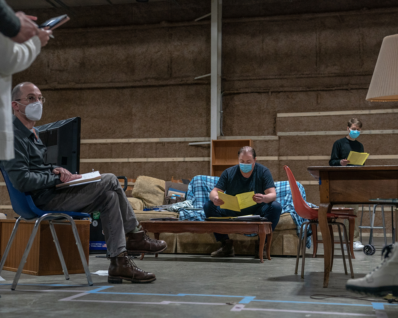 Fotografia da produção do filme A Baleia, na imagem se destacam o diretor Darren Aronofsky e o ator Brendan Fraser, que parece ler um roteiro.